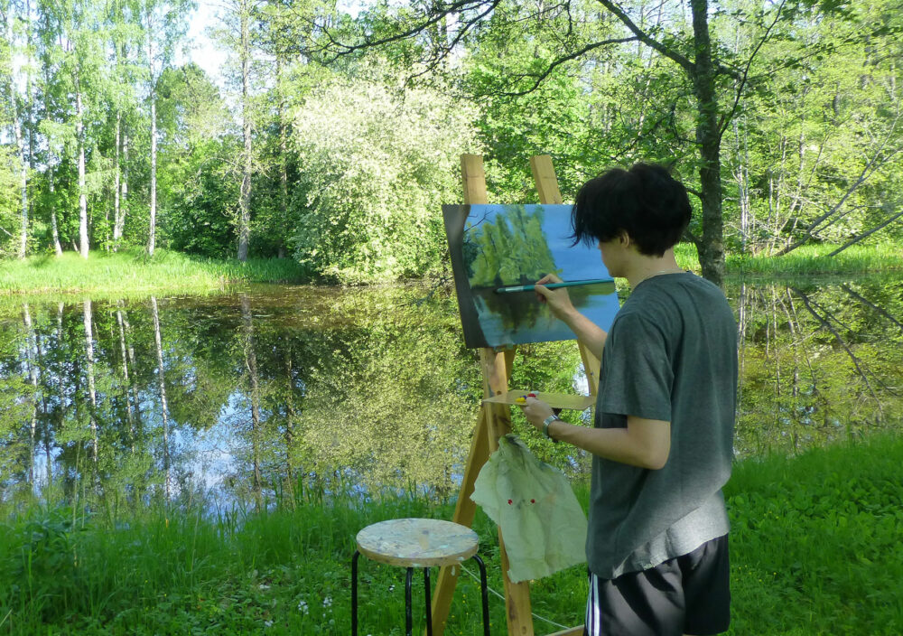 Konstbild målar vid ån